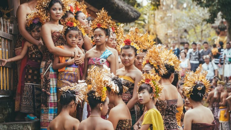 Tenganan Duah Tukad, Bali, Indonesien - July 26, 2013: Group of Balinese people. Beautiful dancer women in traditional costumes dance on street parade at art and culture festival.