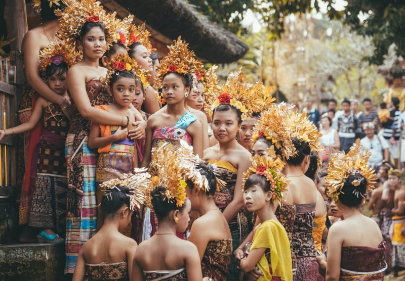 Tenganan Duah Tukad, Bali, Indonesien - July 26, 2013: Group of Balinese people. Beautiful dancer women in traditional costumes dance on street parade at art and culture festival.